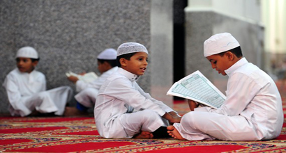 A child reciting the Qur'an and the other is listening to him.