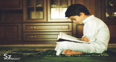 A little boy is reading the Qur'an.