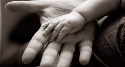 A Baby holding his father's hand